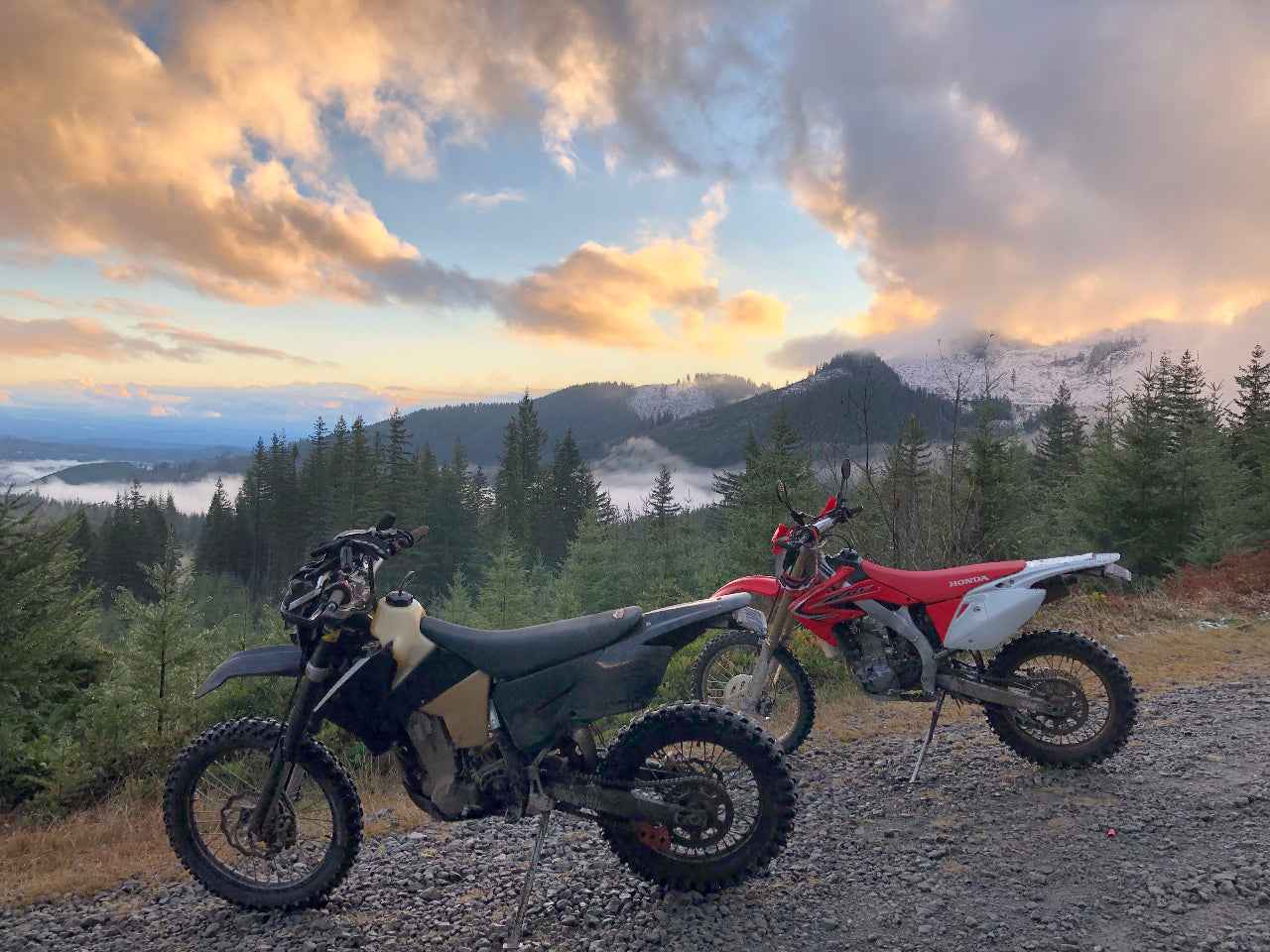 Two dirt bikes on a trail with sky in the background